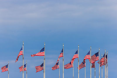 Low angle view of flags against blue sky