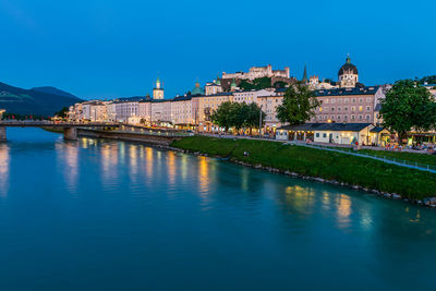 Arch bridge over river against buildings