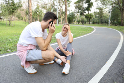 Young couple sitting on road