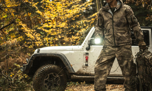 Rear view of man standing in forest during autumn