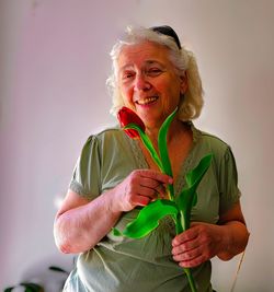 Happy elderly woman with a red tulip.