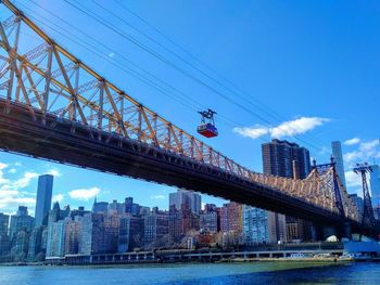 Low angle view of bridge and buildings against sky