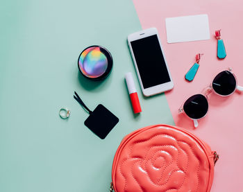 Directly above shot of smart phone with beauty products on table