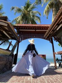 A female model in front of the beach gate againsy blue sky