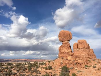 View of rock formation against cloudy sky