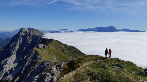 Family hiking on mountain against sky