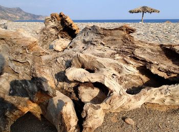 Rock formation on beach against sky