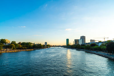 River amidst buildings in city against sky