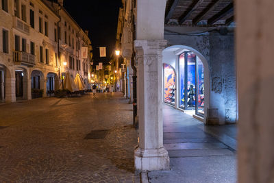 Illuminated street amidst buildings at night