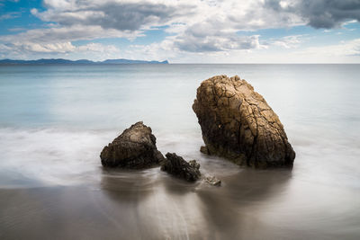 Rocks in sea against sky