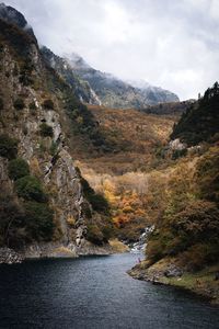 Scenic view of river and mountains against sky