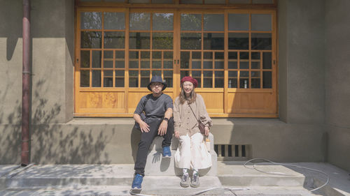 Full length of couples standing outside building