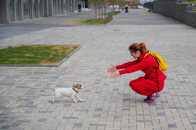 Side view of woman with dog on footpath