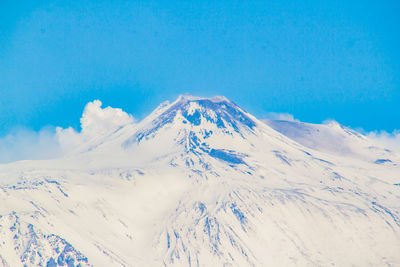 Scenic view of snowcapped mountains against blue sky