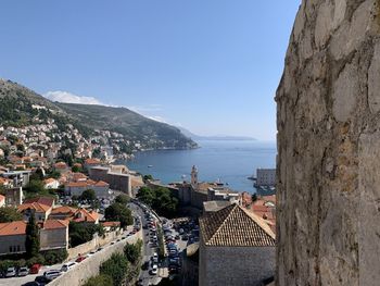 Townscape by sea against clear blue sky