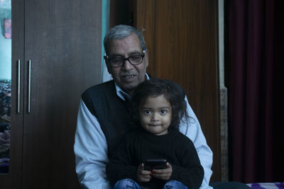 Portrait of happy boy using mobile phone