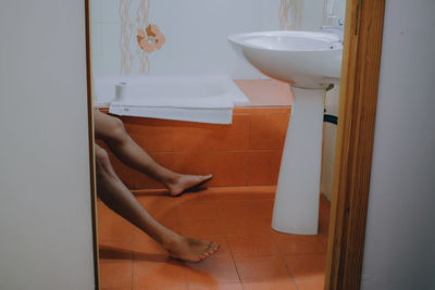 Low section of person in bathroom at home