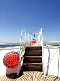 Boats in river against clear blue sky