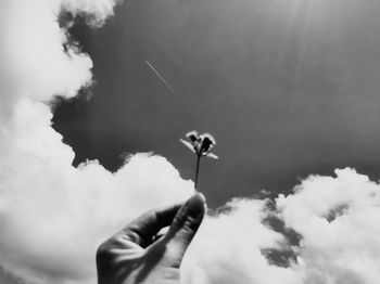 Low angle view of hand against sky