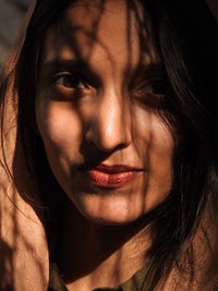 Close-up portrait of woman with shadow on face