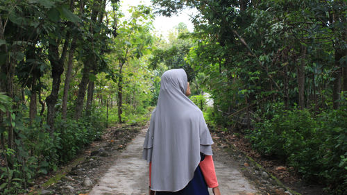 Rear view of woman walking in forest