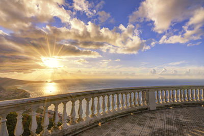 Observation point by sea against sky during sunset