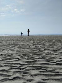 People on beach against sky