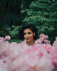 Portrait of woman with pink flower in garden