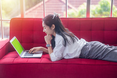 Side view of young woman using mobile phone