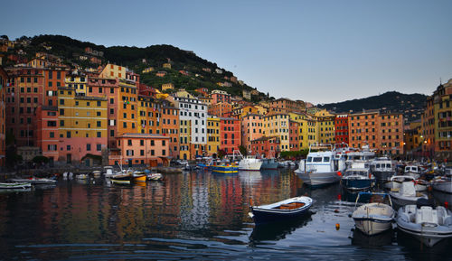 Boats moored in canal against buildings