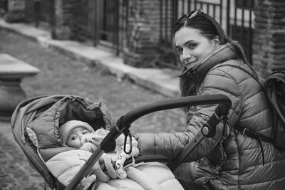 Portrait of young woman sitting on street