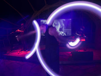Blurred motion of people standing in the dark