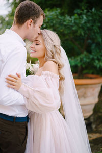 Couple embracing during wedding ceremony outdoor