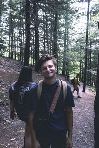 Portrait of smiling woman standing in forest