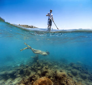 Young couple have a fun in ocean water, underwater view