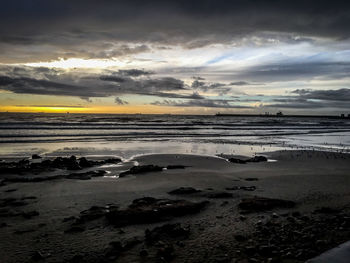 Scenic view of beach against sky during sunset