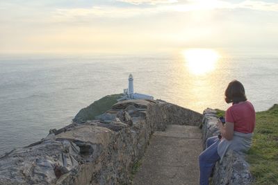 Rear view of woman looking at sea against sky