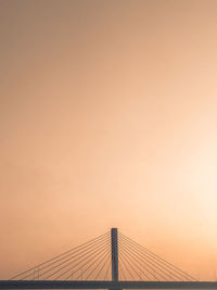 Low angle view of suspension bridge against sky during sunset