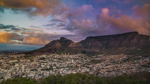 Cityscape against mountain at sunset