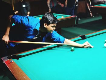 High angle view of young man playing pool ball