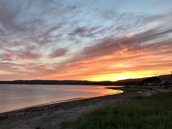 Scenic view of sea against dramatic sky during sunset