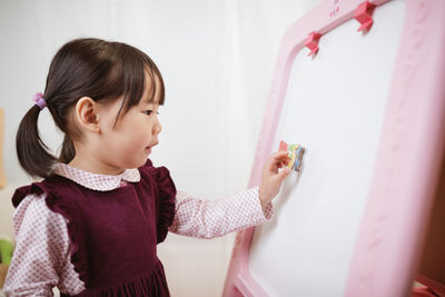 Cute girl cleaning whiteboard