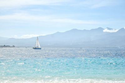 Sailboat sailing on sea against sky