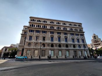 Building by street against sky in city