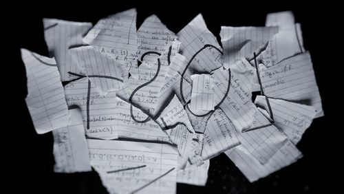 High angle view of torn papers on black background