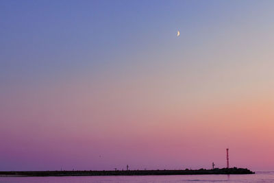 Scenic view of sea against clear sky at sunset