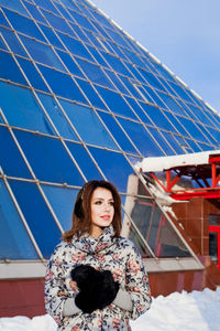 Portrait of young woman standing against blue sky