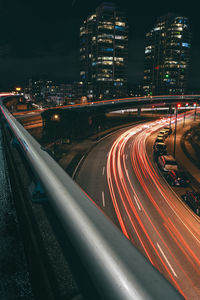 High angle view of light trails on street amidst buildings in city