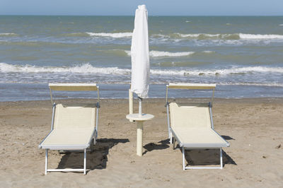 Chairs on beach against sea