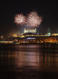 Firework display over river at night